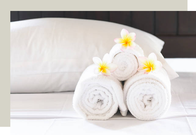 Towel rolls organized and stacked on hotel bed